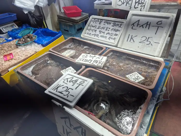 다양한 종류의 해산물이 담긴 수조와 가격표가 붙어있는 모습