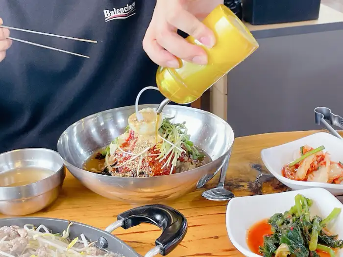 막국수에 양념 추가하는 모습