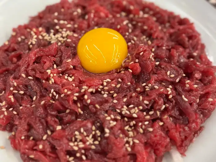 신선한 육회 위에 계란 노른자가 올려진 모습