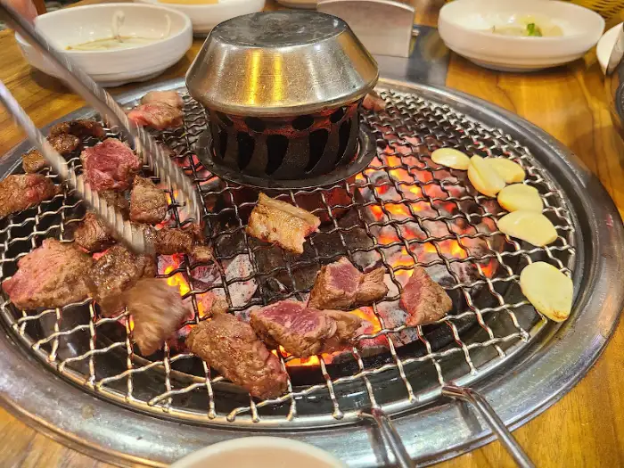 집게로 집어 올리는 육즙 가득한 한우