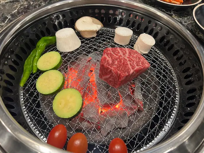 불판 위에서 맛있게 익어가는 한우와 야채