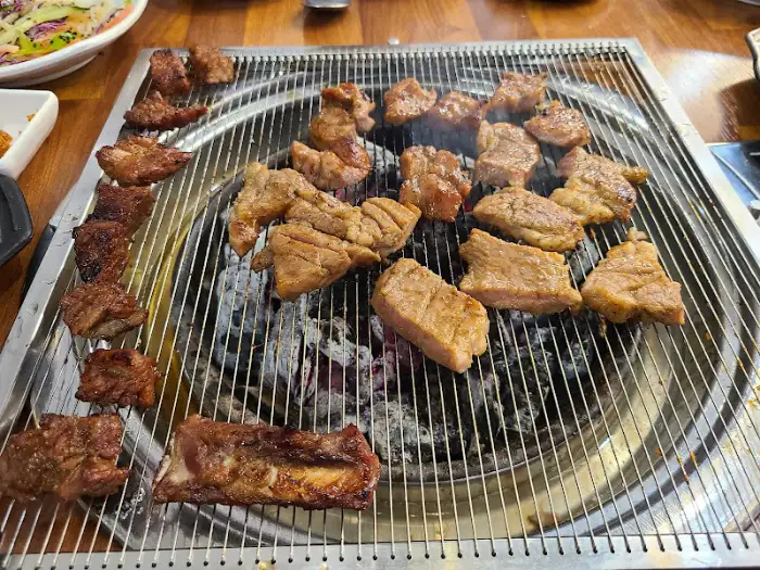 다양한 크기와 모양으로 숯불 위에서 익고 있는 돼지갈비들