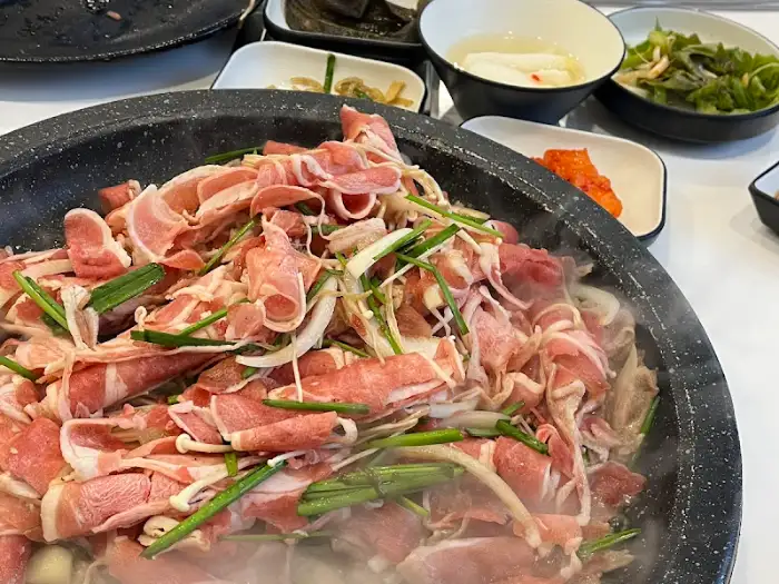 식탁 위에 차려진 다양한 밑반찬과 메인 메뉴가 올라갈 불판