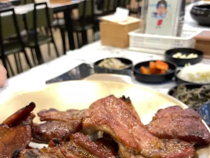 잘 구워진 돼지갈비가 접시에 가득 담겨 있다