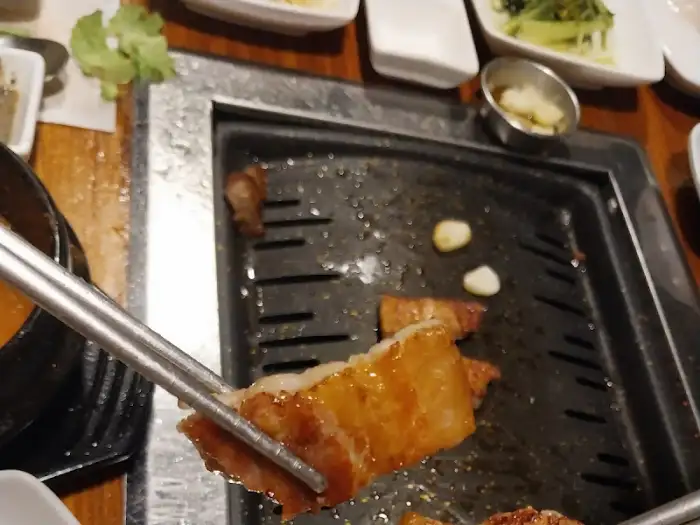 집게로 집어 올린 고기 한 점