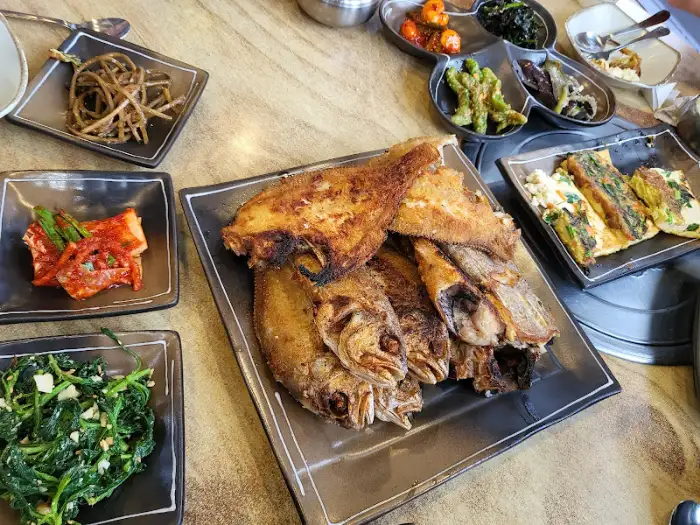 다양한 반찬과 생선구이가 차려진 테이블