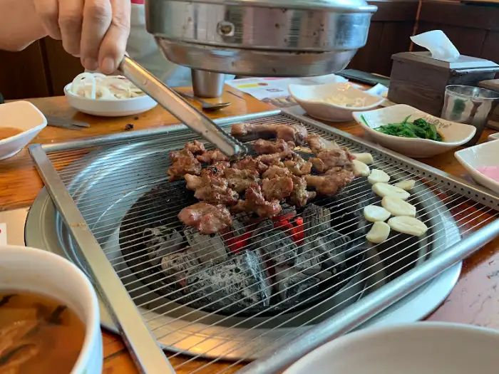 집게로 돼지갈비 조각을 뒤집는 모습