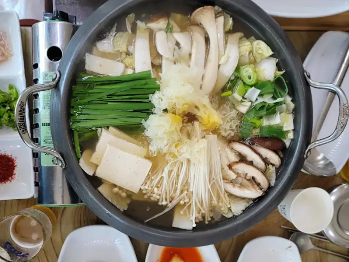 전골 냄비 안의 다양한 재료와 국물 클로즈업