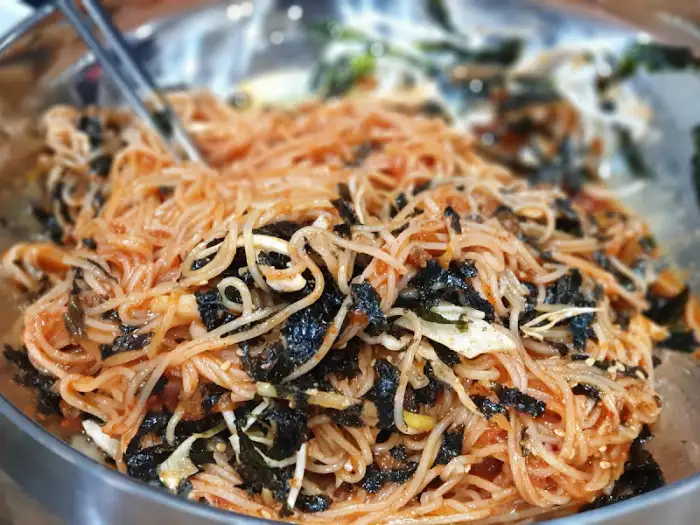 붉은 양념과 김가루가 뒤섞인 비빔국수 클로즈업