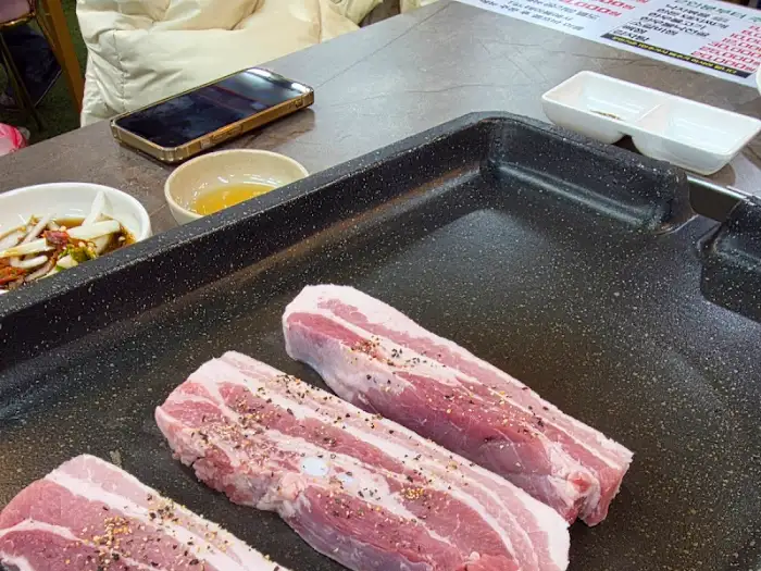 테이블에 놓인 불판과 삼겹살
