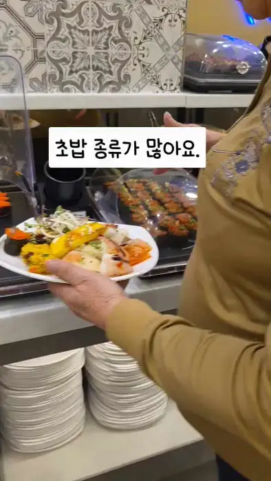 초밥 코너에 가지런히 담긴 다양한 초밥과 롤