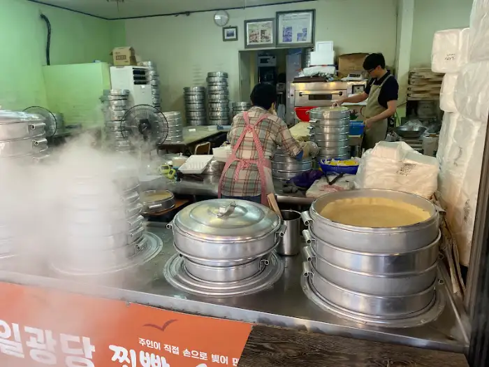 가게 내부에서 찜기에서 만두를 꺼내는 모습