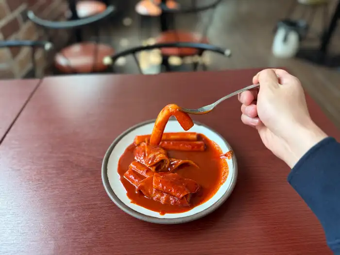 포크로 떡볶이 떡을 집어 올리는 모습