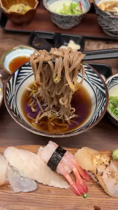 집게로 냉모밀 면발을 건져 올리는 모습.