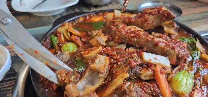 가위로 갈비찜을 자르고 있는 모습