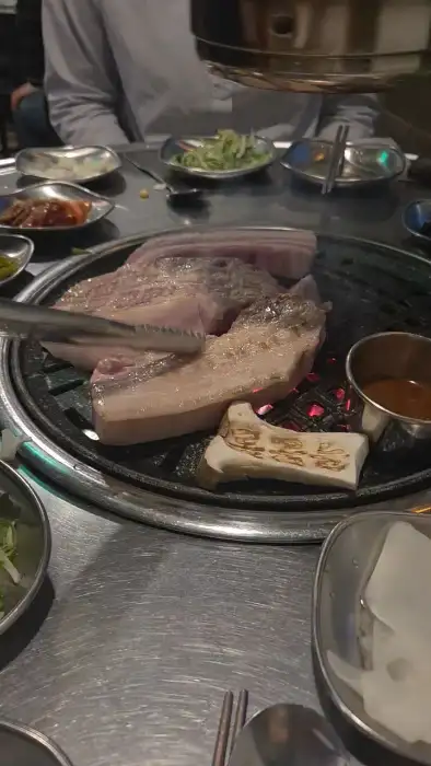 직원이 흑돼지를 불판에 구우는 모습