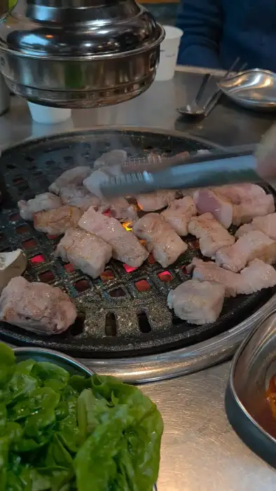 불판 위에서 구워지는 흑돼지 조각들