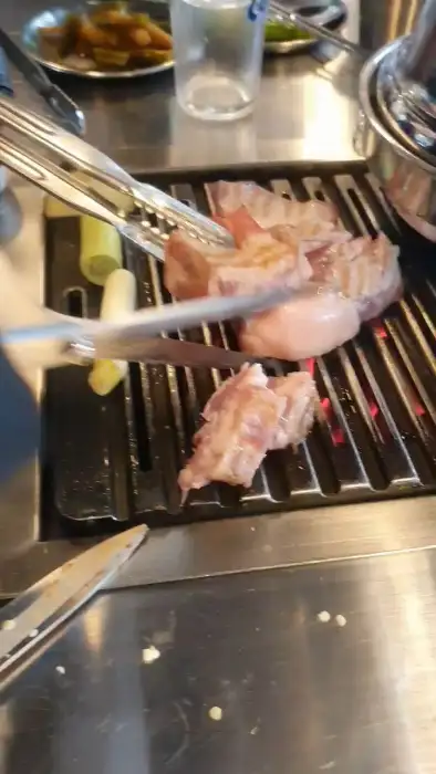 숯불 위에서 구워지는 두툼한 고기