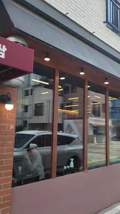 건물 외부 모습, 통유리창으로 안쪽이 보이는 구조.