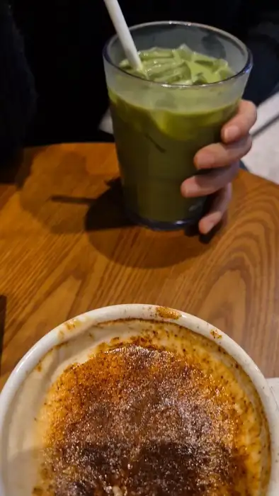 손이 들고 있는 말차 라떼와 크렘 브륄레