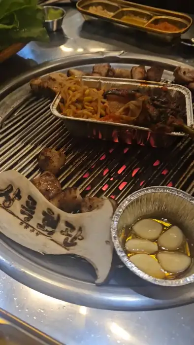 불판 위에서 익어가고 있는 고기와 곁들임 메뉴
