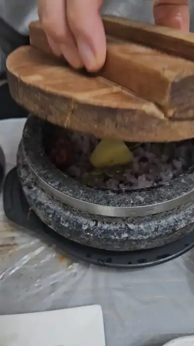 돌솥뚜껑을 열고 밥을 확인하는 모습