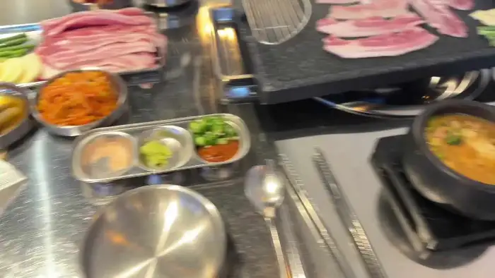 테이블 위에 세팅된 반찬과 쌈 채소, 소스 등이 담긴 그릇들