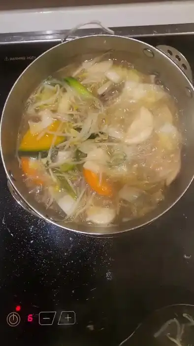 끓고 있는 샤브샤브 냄비에 채소가 가득 담긴 모습