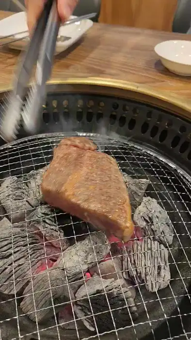 숯불 위에서 익어가는 두툼한 고기 덩어리