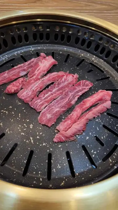 불판 위에 가지런히 놓인 얇게 썬 갈빗살