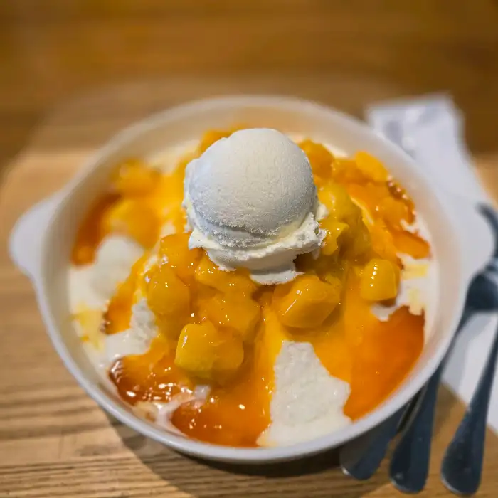 망고 빙수에 아이스크림 한 스쿱이 올라가 있는 모습