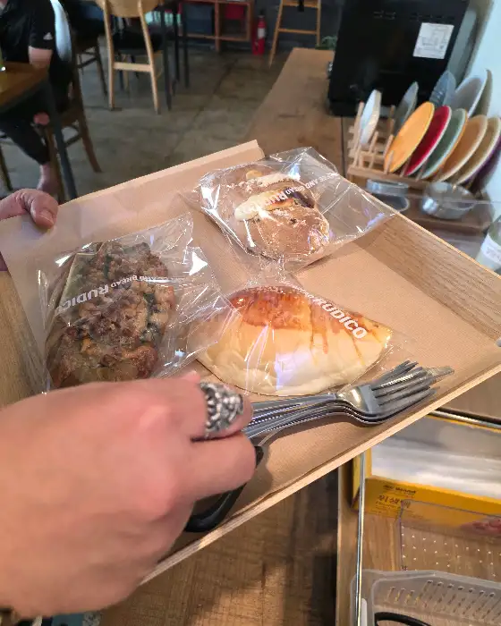트레이에 담긴 여러 개의 빵과 포크, 그리고 손목의 반지