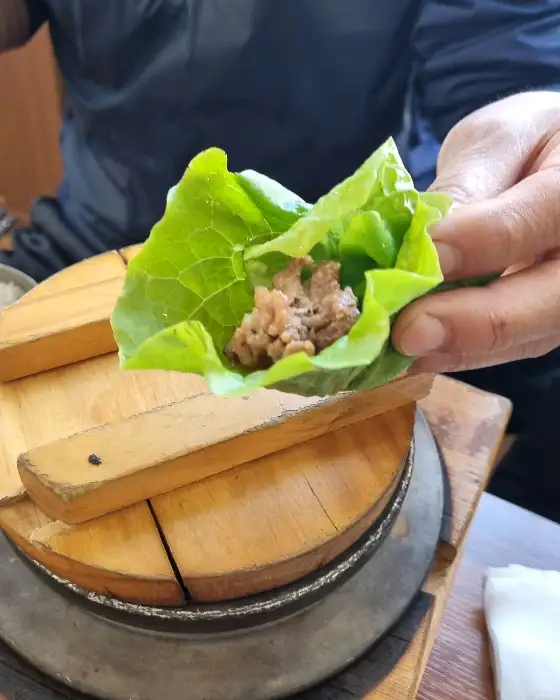 쌈 채소에 고기와 우렁쌈장 얹어 싸먹기
