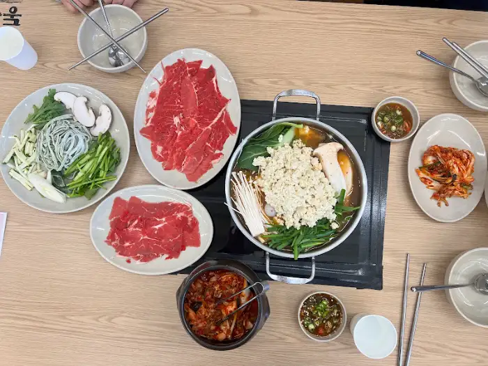 다양한 신선한 채소와 얇게 썬 고기가 준비된 테이블 세팅