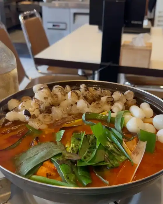 곱도리탕에 익은 대창과 떡, 채소가 보이는 모습