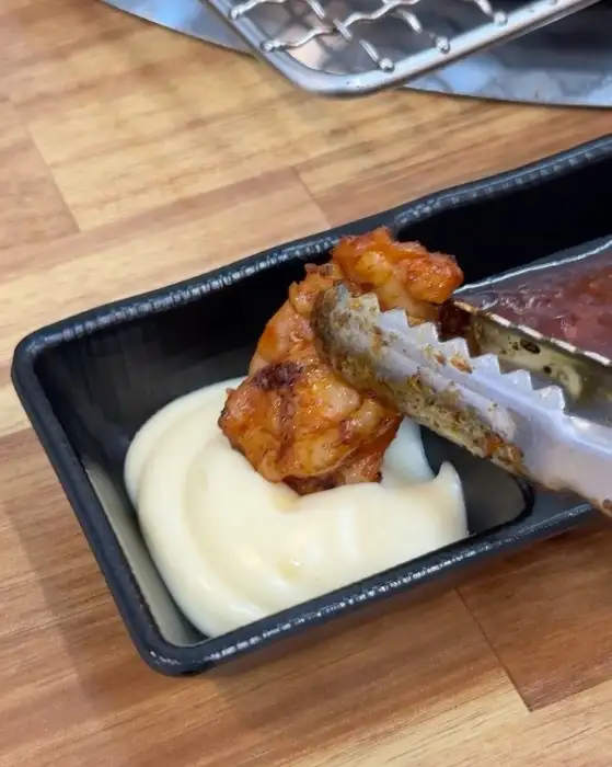 닭갈비 조각을 마요네즈 소스에 찍는 모습