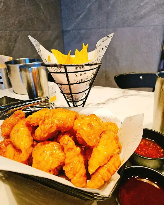바구니에 담겨 나온 치킨과 함께 나온 감자튀김, 소스