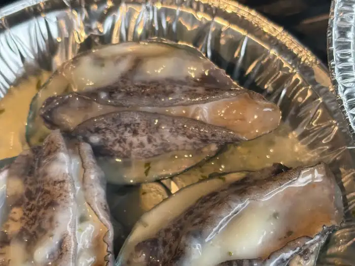 한입 크기로 썰어진 전복이 올리브 오일과 함께 조리되는 모습