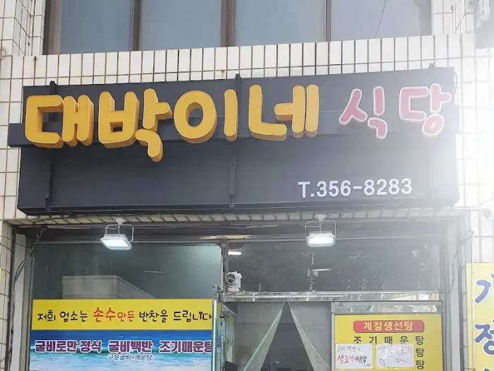 노란색 글씨의 '대박이네 식당' 간판과 그 아래 검은색 LED 전광판이 보입니다.