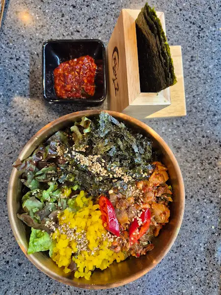 황금빛 밥 위에 신선한 채소와 김, 그리고 양념이 어우러진 비빔밥
