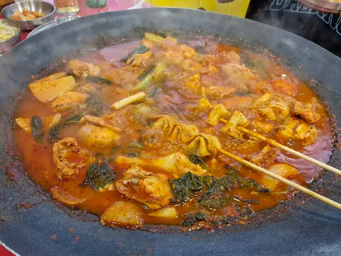 커다란 솥뚜껑 위에서 끓고 있는 닭볶음탕