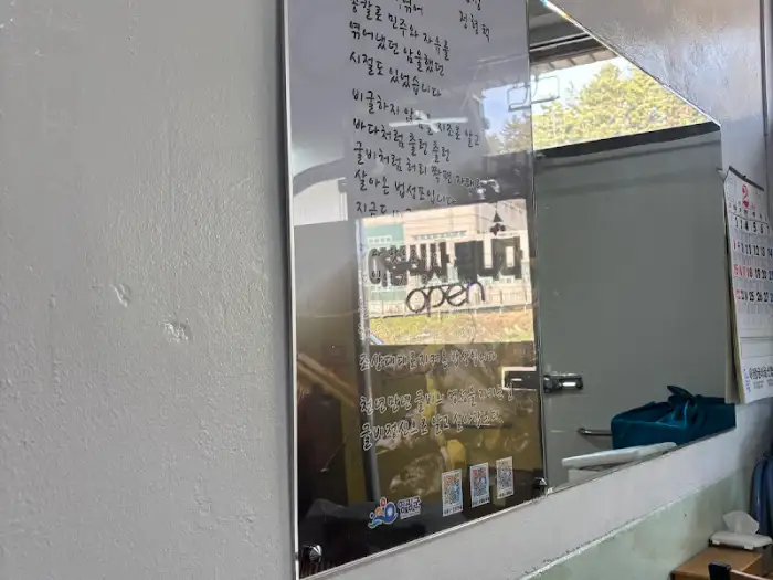 거울에 비친 메뉴판과 '아침 식사 OPEN'이라는 글자가 보입니다.