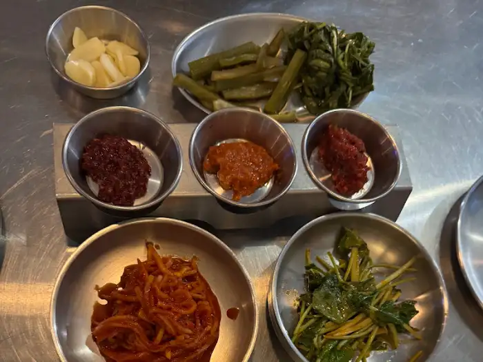 다양한 밑반찬이 담긴 작은 그릇들이 테이블 위에 놓여 있는 모습